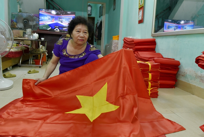 Sau khi may, phần chỉ thừa, vải thừa được bà Mai kiểm tra kỹ để loại bỏ