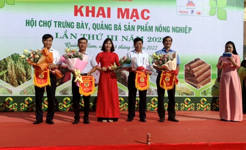 Bà Lê Thị Minh Tâm-Chủ tịch Hội Nông dân tỉnh tặng cờ lưu niệm cho các đơn vị tham gia hội chợ 