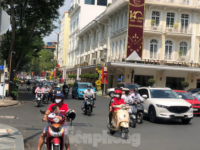 Sài Gòn nhộn nhịp trưa Mùng 1 Tết, dân đeo khẩu trang kín mít đi lễ chùa đầu năm - Ảnh 3.