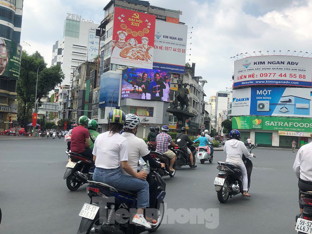 Sài Gòn nhộn nhịp trưa Mùng 1 Tết, dân đeo khẩu trang kín mít đi lễ chùa đầu năm - Ảnh 4.