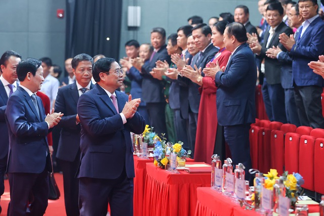 Các đại biểu nhiệt liệt chào mừng Thủ tướng và các đồng chí lãnh đạo Đảng, Nhà nước tới dự lễ kỷ niệm. Ảnh VGP/Nhật Bắc