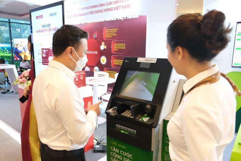 Cán bộ Vietcombank tư vấn khách hàng sử dụng dịch vụ ngân hàng số (ảnh trên) và dịch vụ ATM (ảnh dưới) tại gian hàng trưng bày