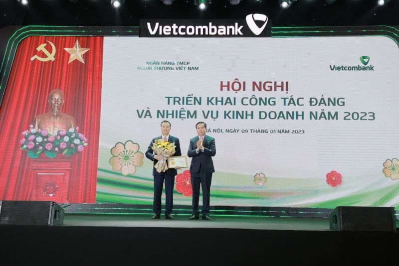 Đ/c Nguyễn Long Hải - Ủy viên dự khuyết Ban Chấp hành Trung ương Đảng, Bí thư Đảng ủy Khối DNTW (bên phải) trao Kỷ niệm chương “Vì sự nghiệp công tác tổ chức xây dựng Đảng” và tặng hoa cho đ/c Phạm Quang Dũng - Ủy viên Ban Thường vụ Đảng ủy Khối DNTW, Bí thư Đảng ủy, Chủ tịch Hội đồng quản trị Vietcombank (bên trái)